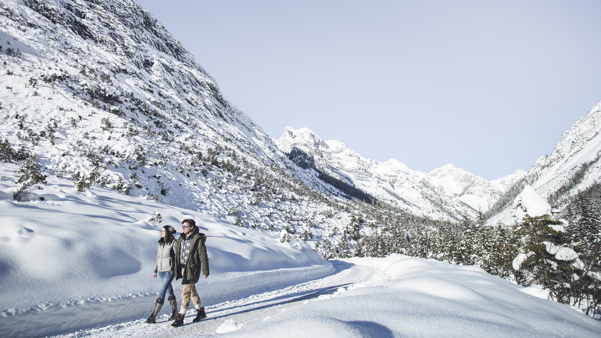 Sehenswürdigkeiten in Seefeld: unsere Tipps Zwei Personen wandern auf schneebedecktem Weg in verschneiten Bergen bei klarem Himmel