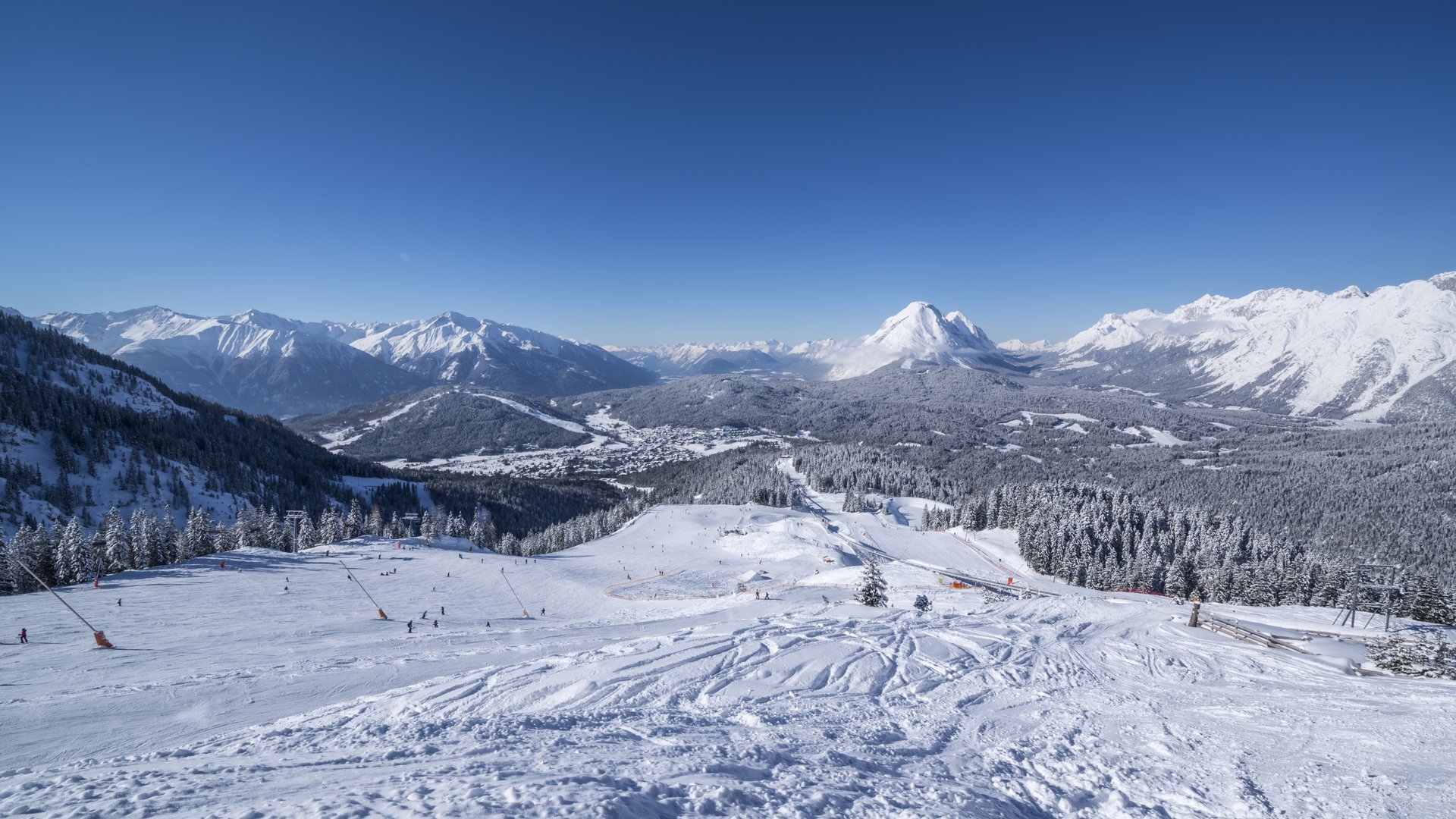 Verschneite Skigebiet mit Bergen und blauem Himmel bei klarem Wetter