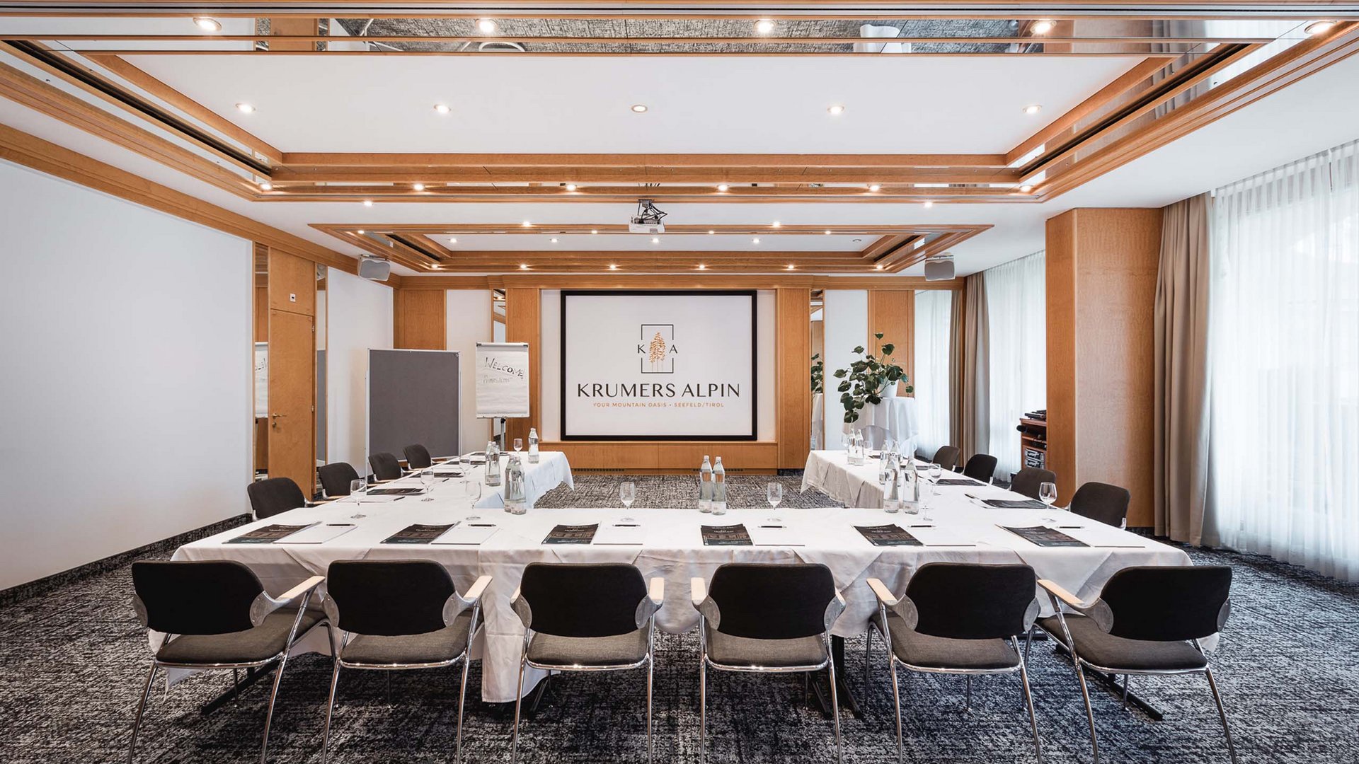 Seminarhotel in Tirol nach Ihrem Geschmack Moderner Tagungsraum mit U-förmigen Tischen und Fenstern mit Vorhängen