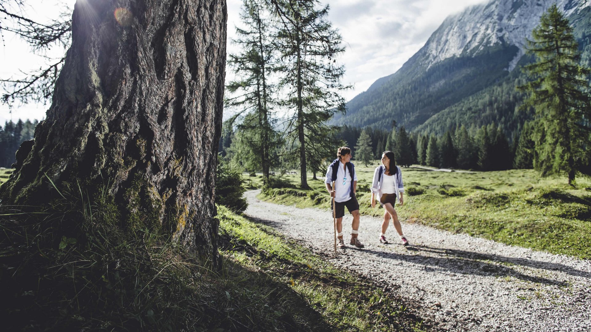 Your holiday in Seefeld, Tyrol Two hikers walking on a forest path with mountains in the background