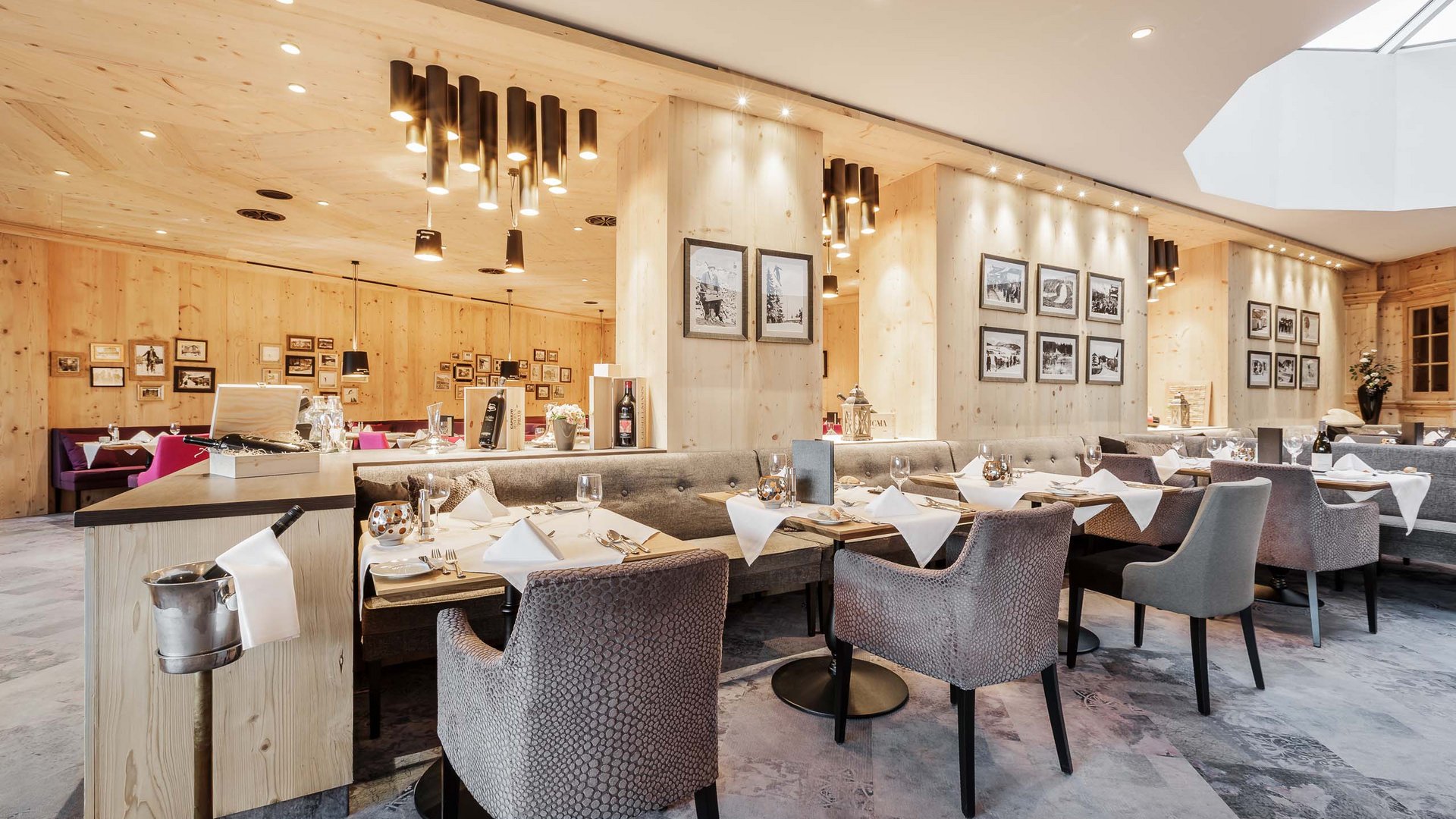 Interno luminoso del ristorante con pareti in legno e tavoli apparecchiati